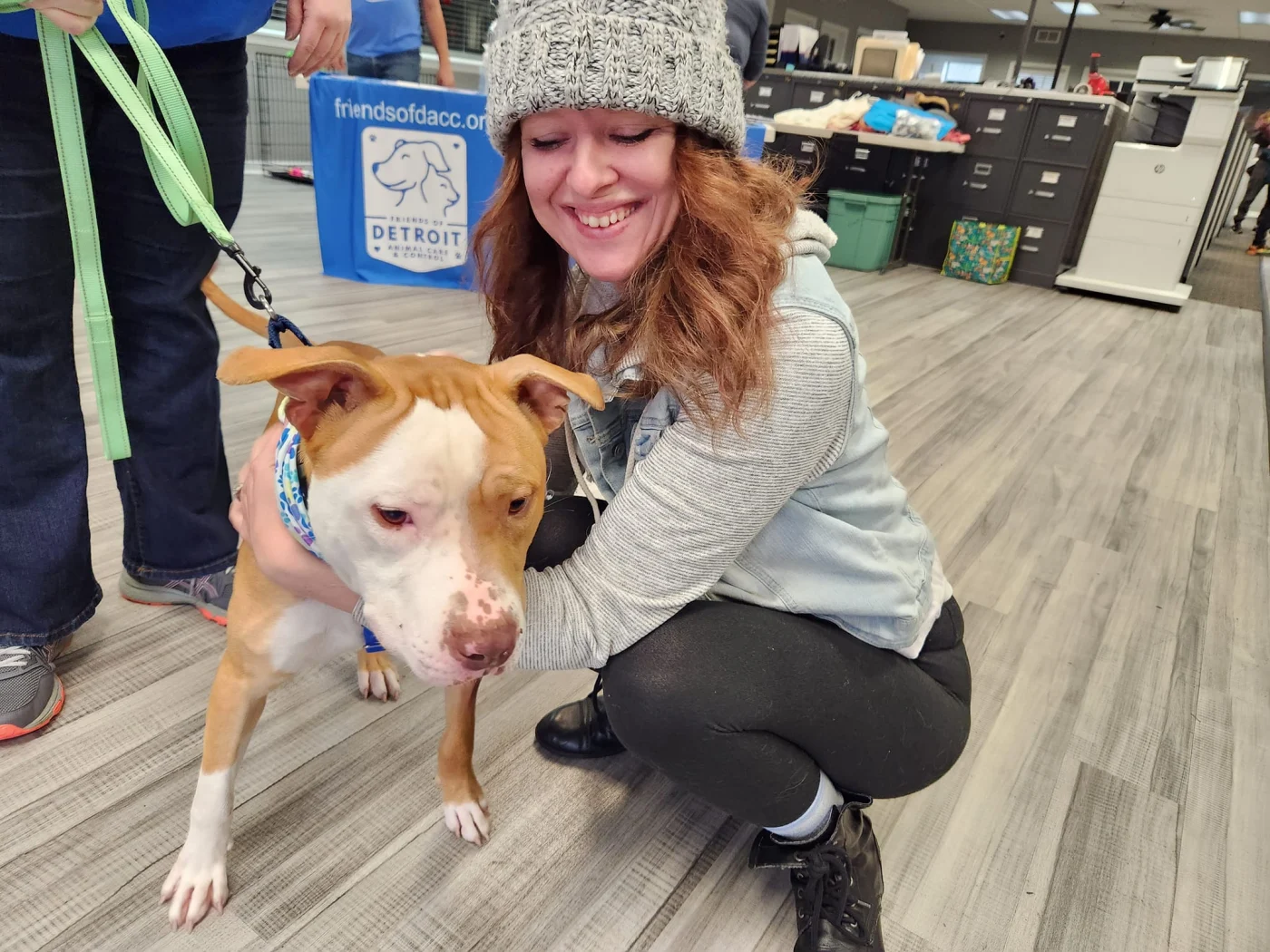 A woman happily adopting a dog.