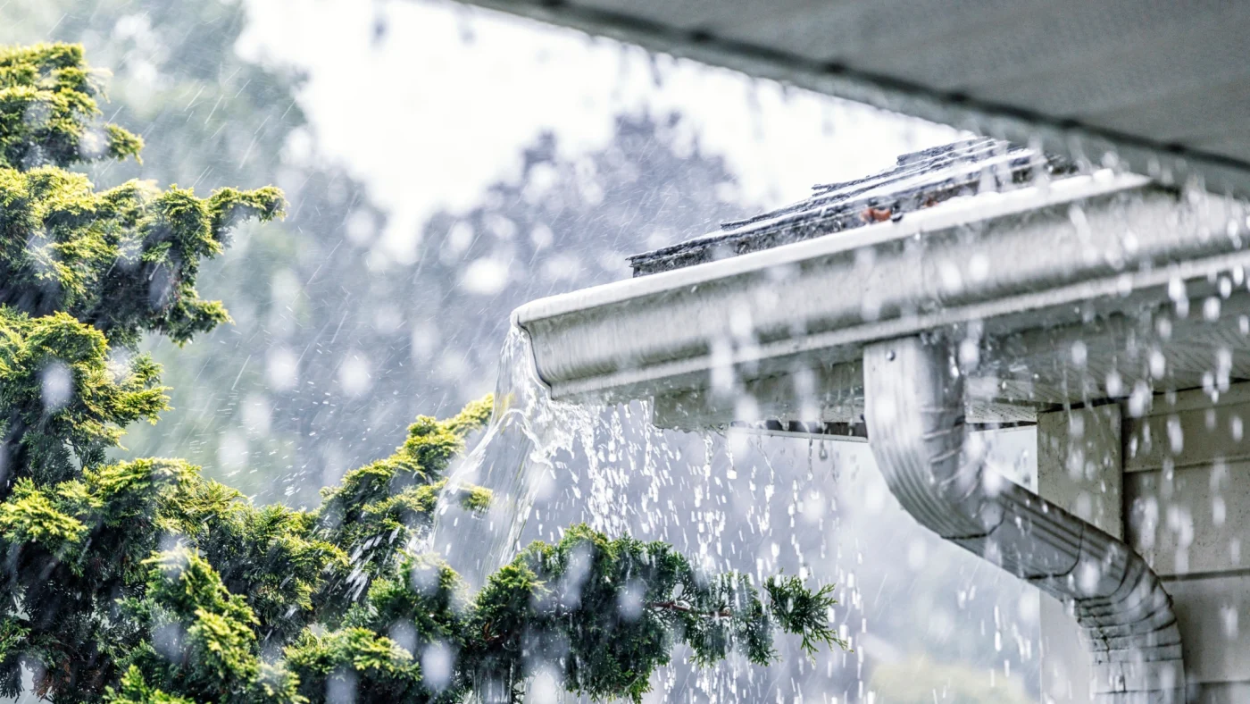 Rain battering a residential gutter.