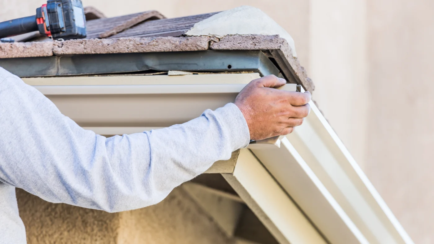 A man installing a seamless gutter.