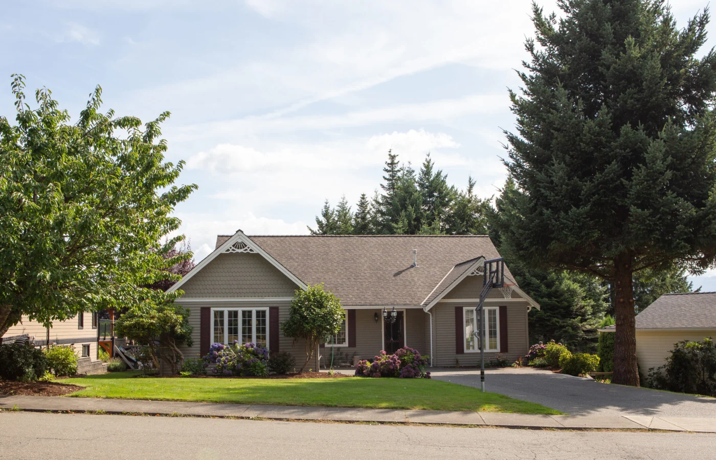 Brown Asphalt Roof On Tan House In Residential Neighborhood