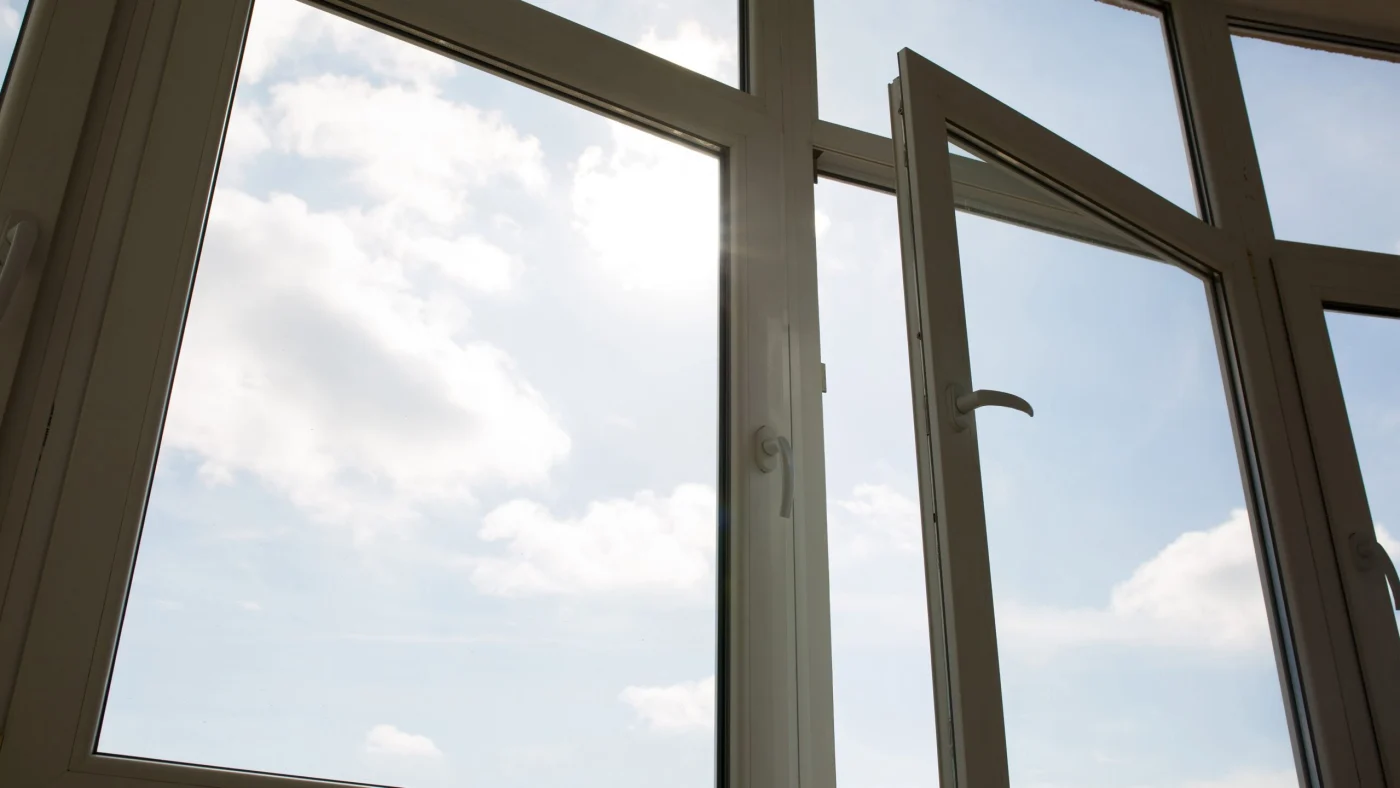 Vinyl windows unlatched overlooking sky