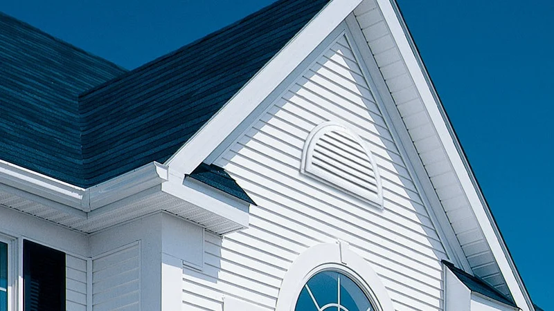 Closeup of the upper floor of a home with white siding