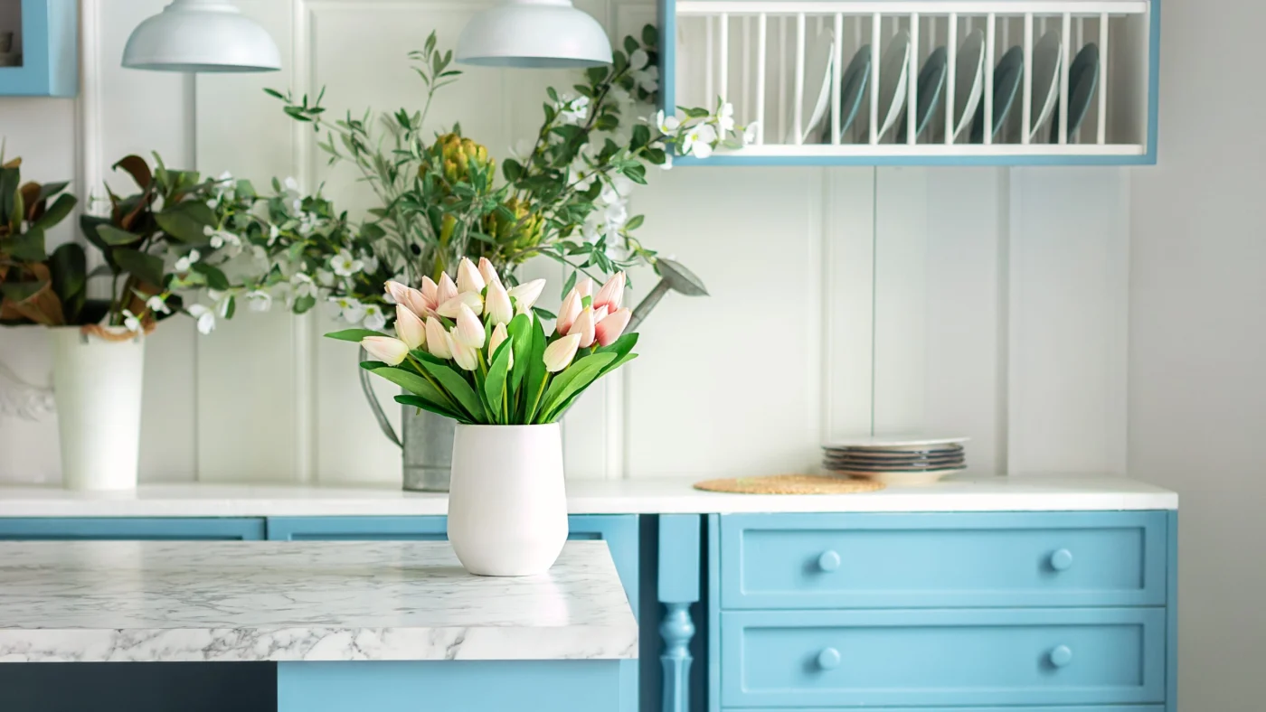 Spacious cottage kitchen with blue cabinets, granite countertops, and spring decor
