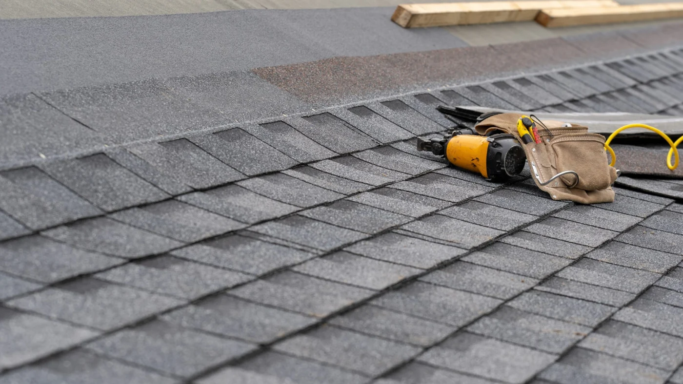 Incomplete asphalt shingle roof with tool belt