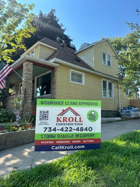 Roof repaired after storm damage with Kroll Construction sign in yard