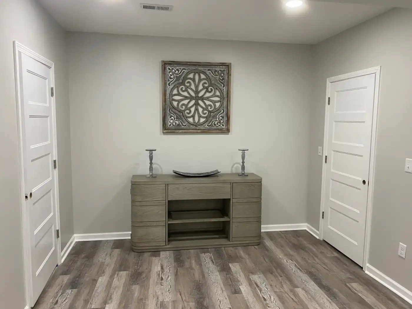 Remodeled basement with gray flooring and two white doors