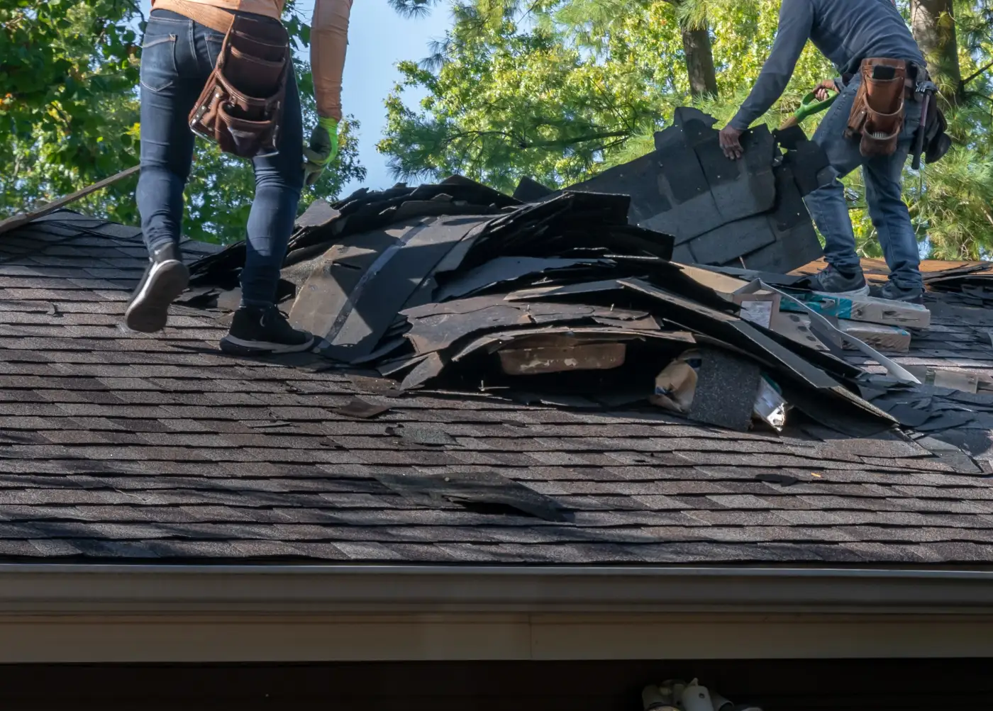 Workers fixing roof damage after a storm