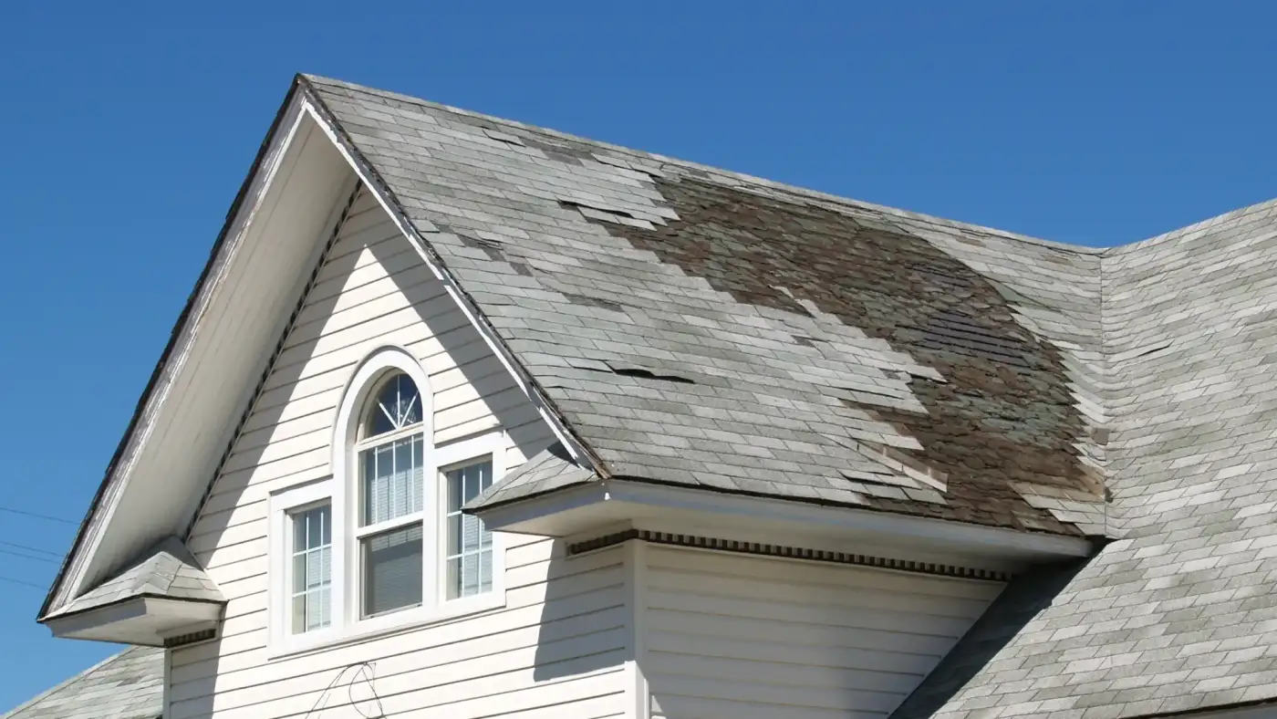 Asphalt shingle roof with missing shingles due to storm damage