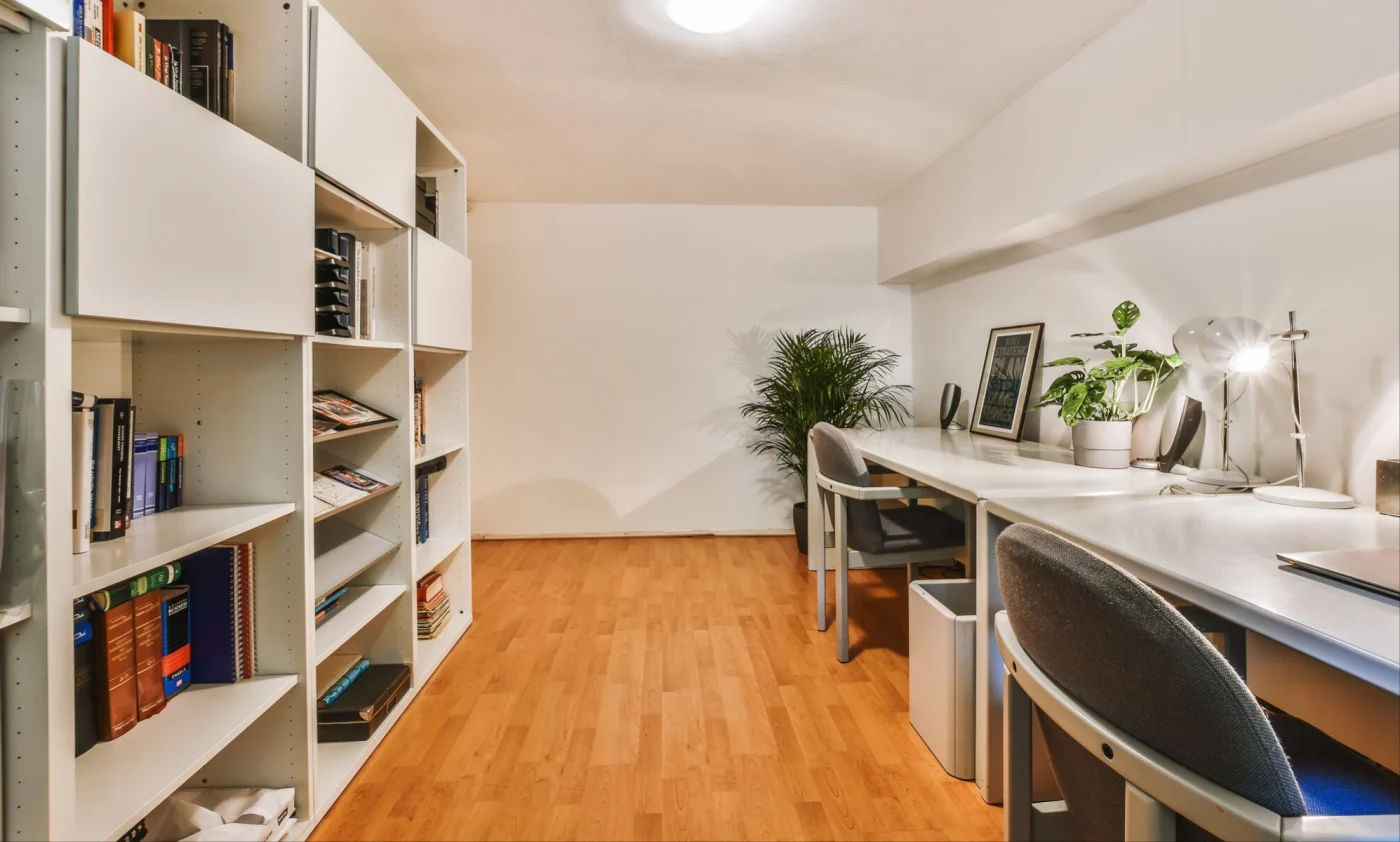 Image of a large basement office with a large shelving system and wooden floors
