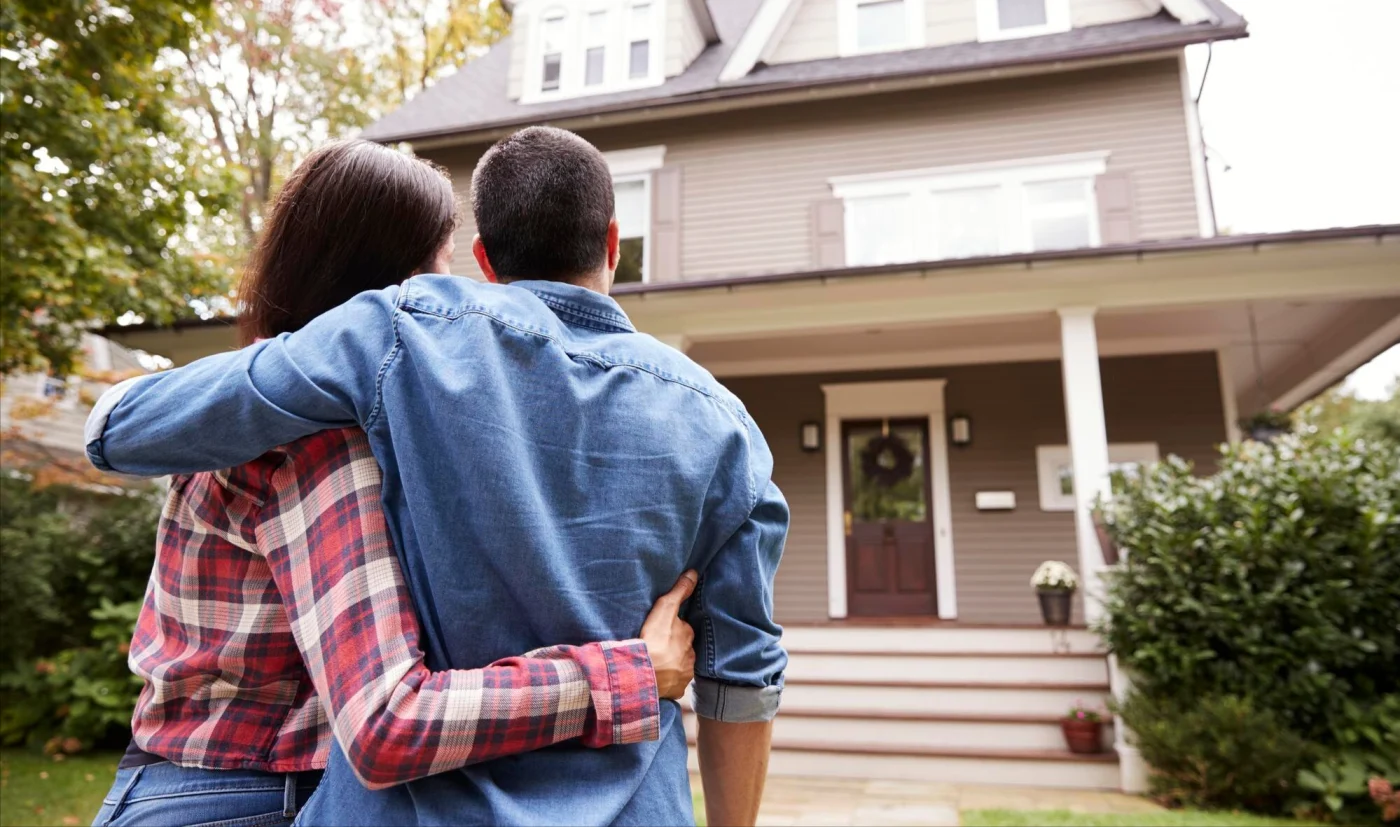 Image of two people looking at a two-story house