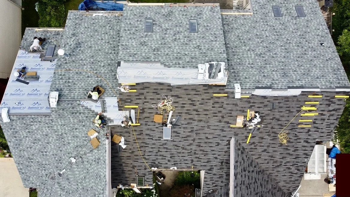 Drone view of roofers doing a roof replacement on a Michigan home