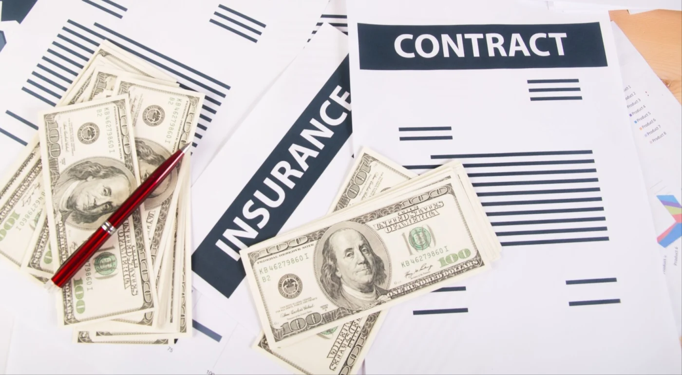 Image of scattered insurance papers and money on a table