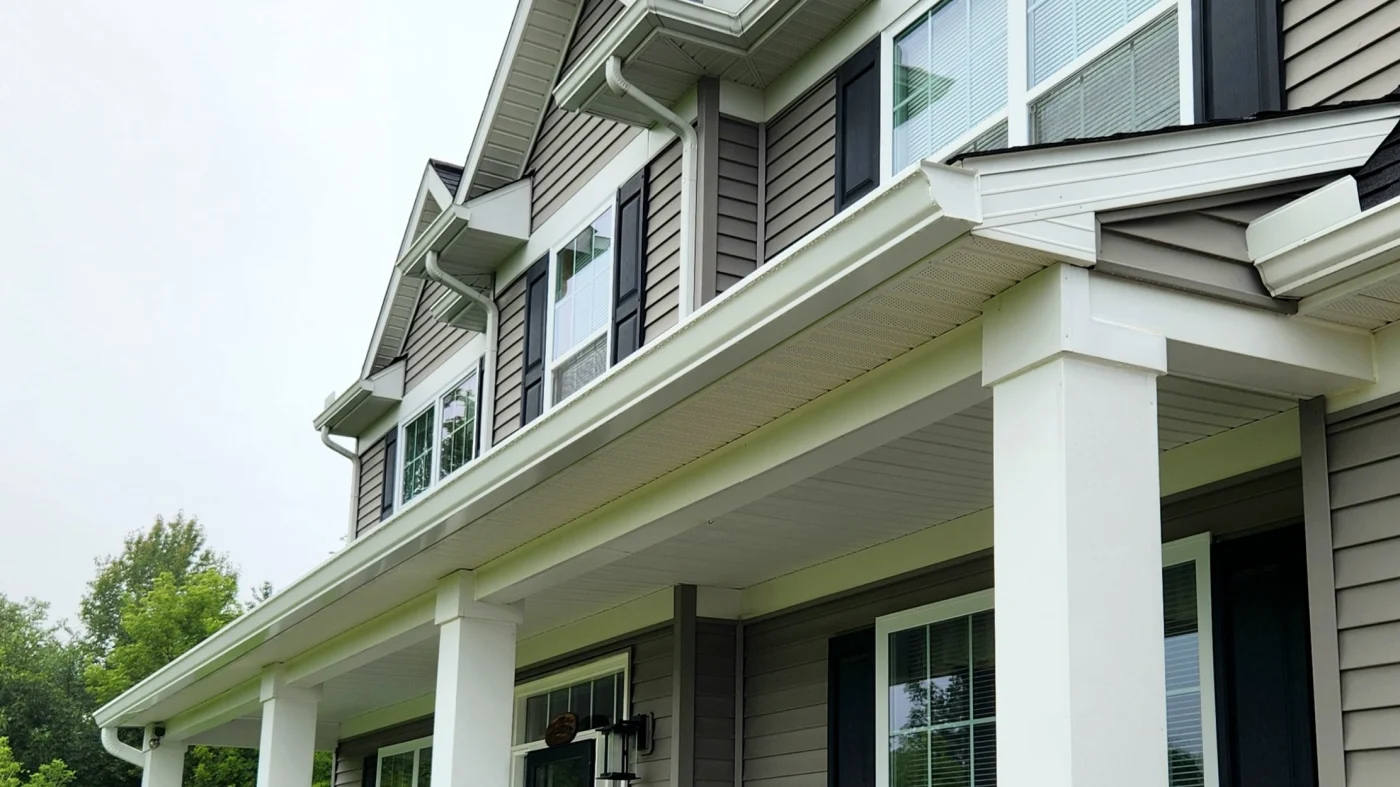 Front of home with newly installed white seamless gutters