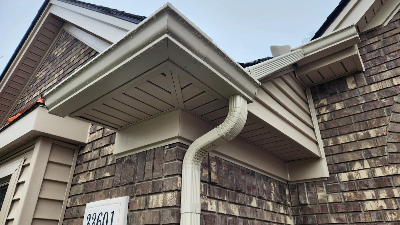 Corner of home with newly installed white seamless gutters