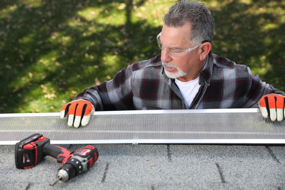 A Kroll Construction technician installing LeafBlaster gutter guards as part of a gutter replacement project.