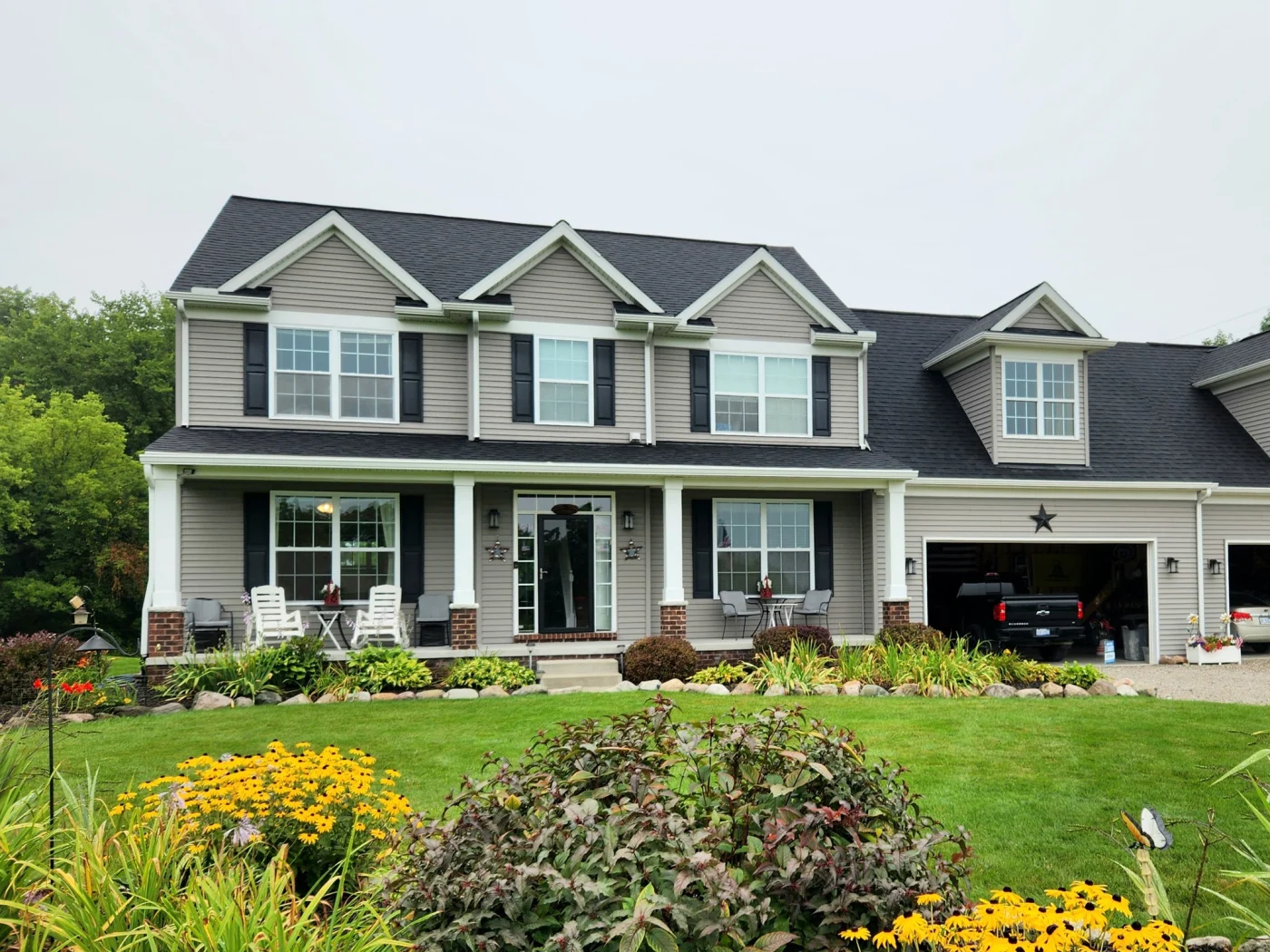 An image of a gray and white home after a siding and gutter replacement.