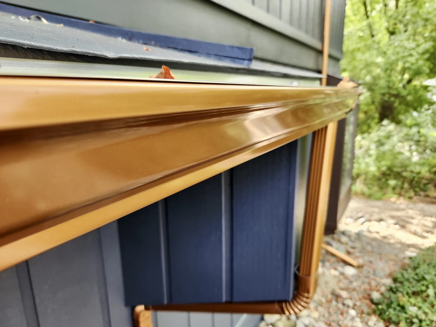 Gold seamless gutters on a blue house.