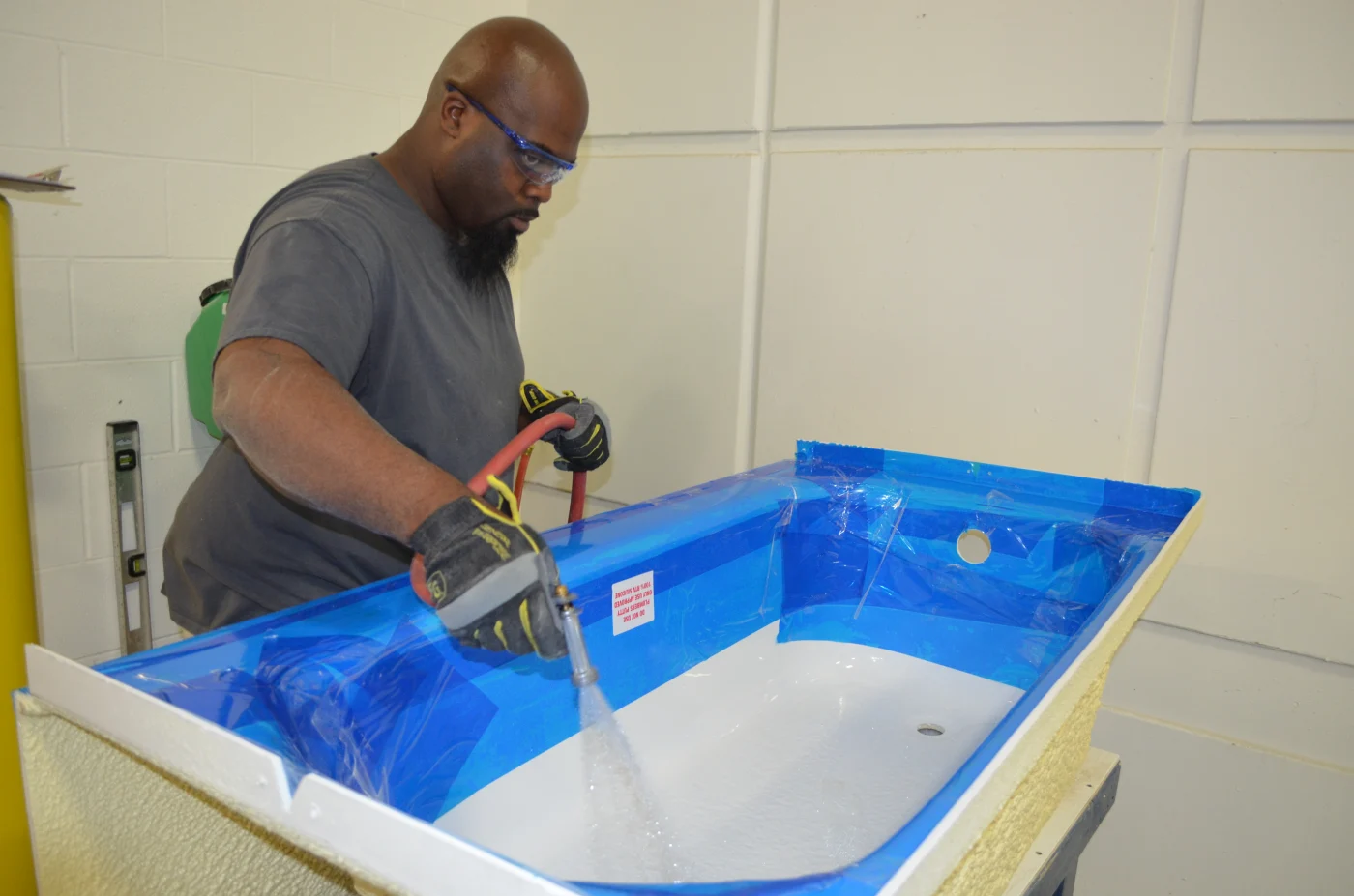 A manufacturer completes the coating on a Luxury Bath system