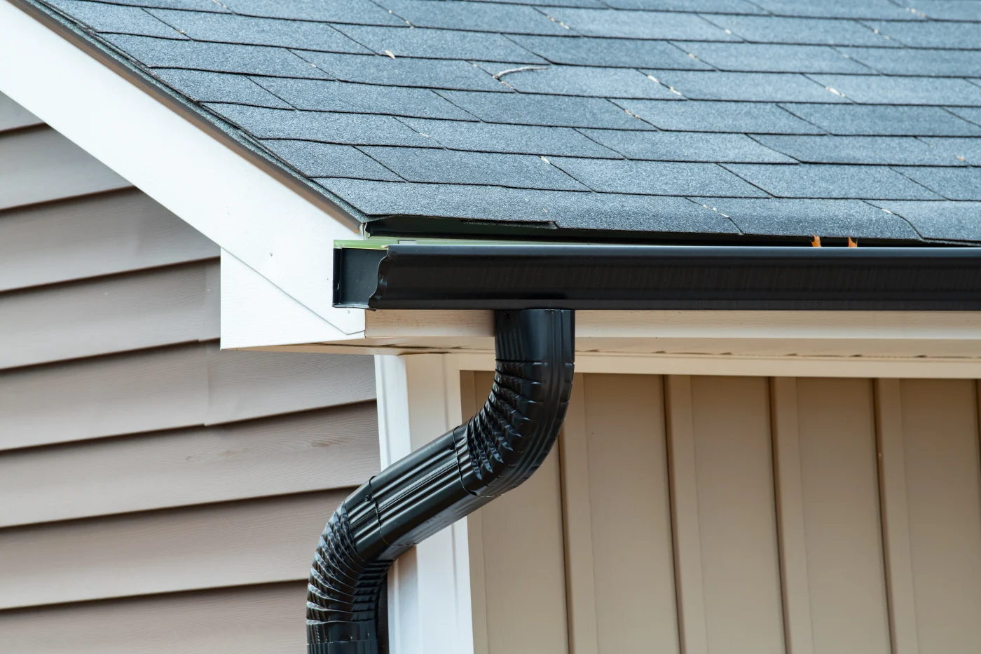 A close-up view of black seamless gutters installed on home