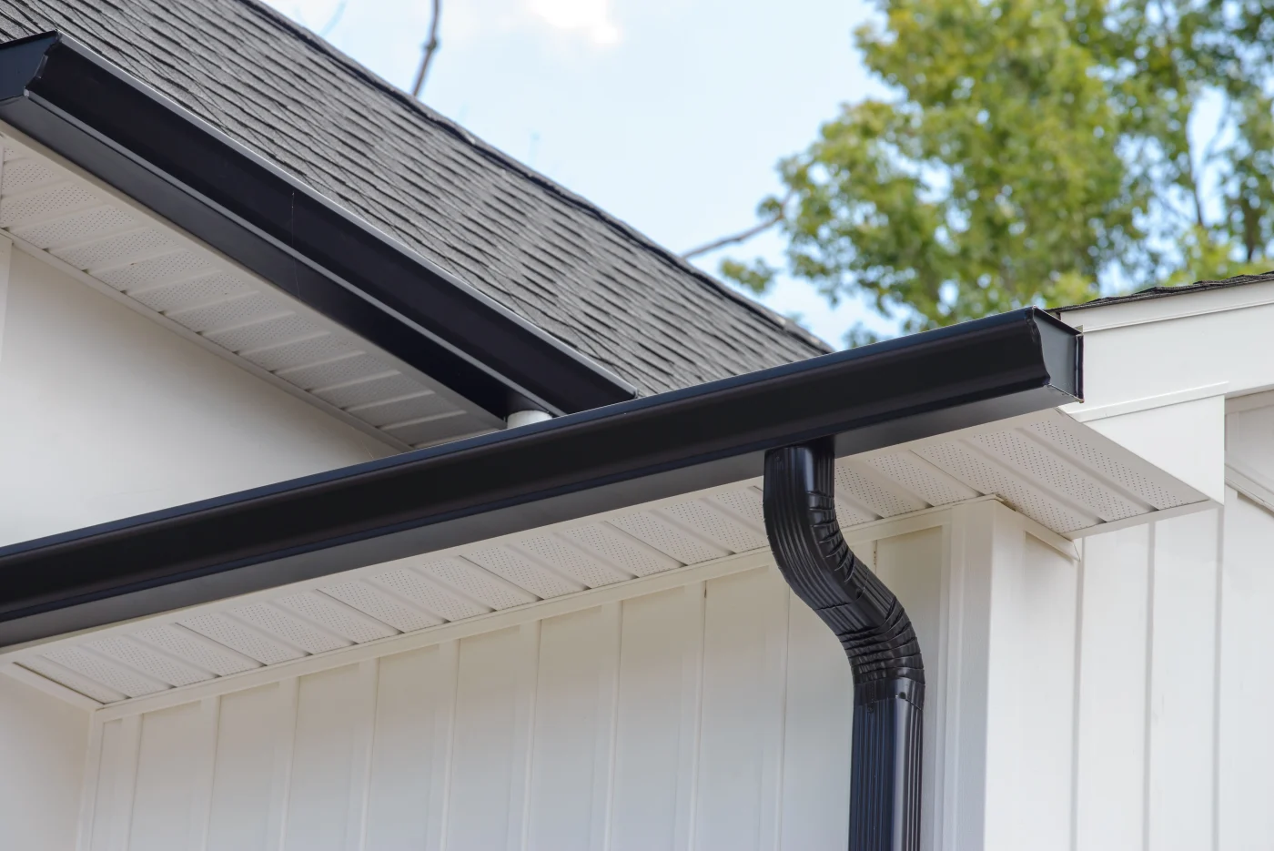 A  black gutter system installed on a white house