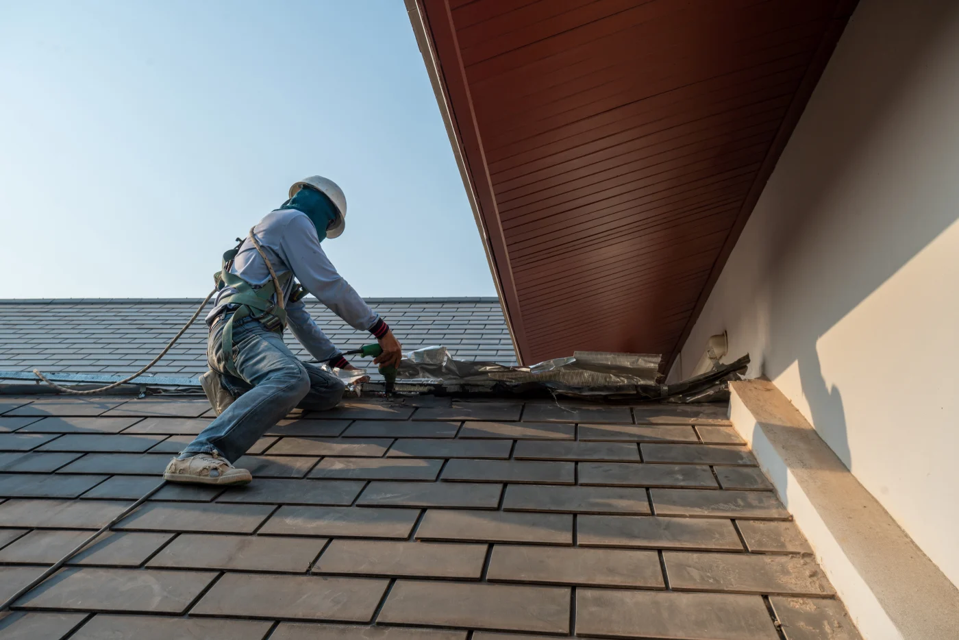 A roofer is replacing the roof of a house.