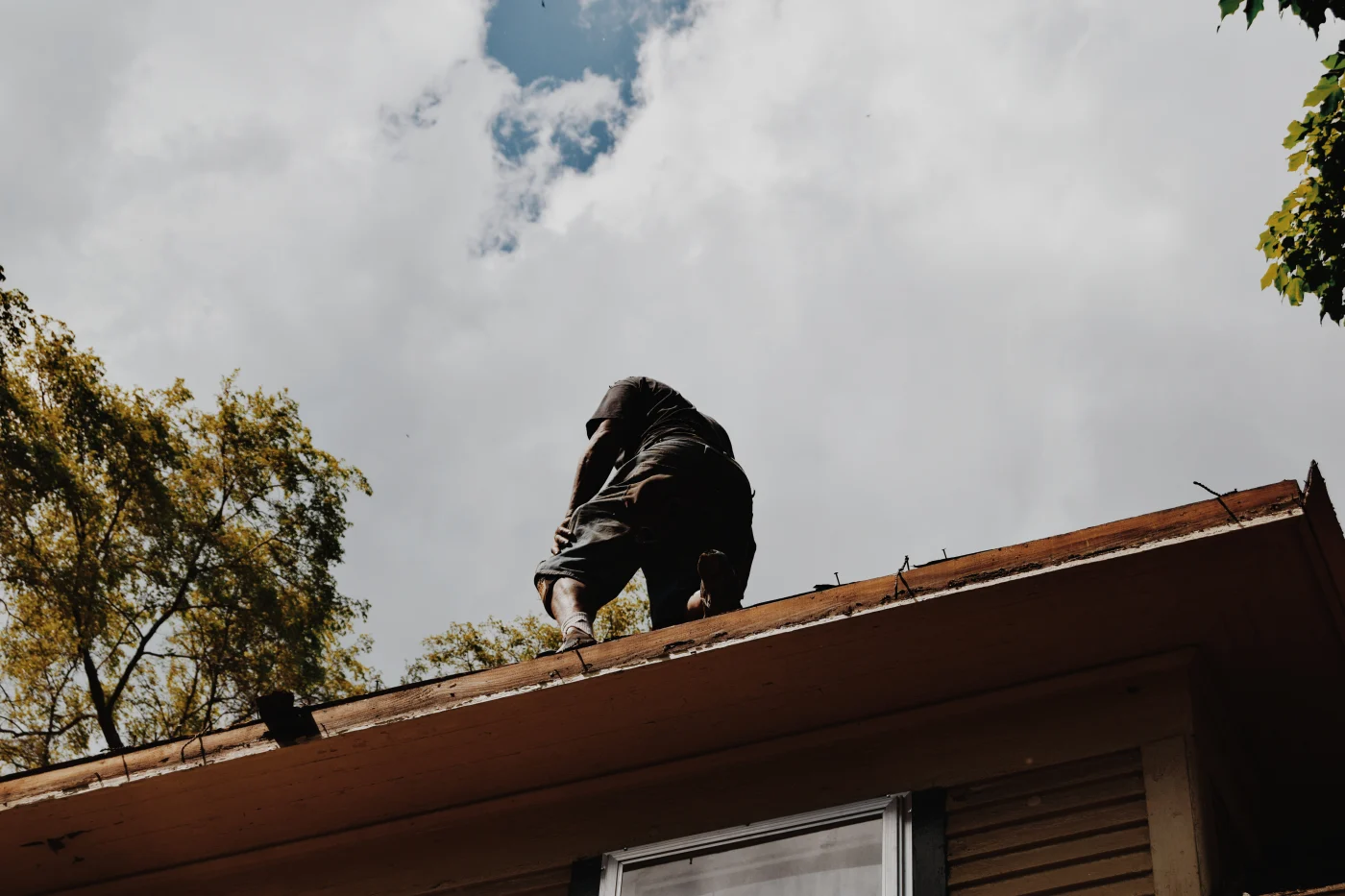 A roofer making repairs to a roof after storm damage.