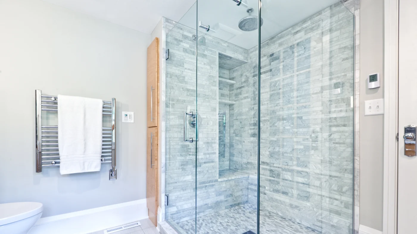 Custom walk-in shower with tile surround and frameless glass enclosure installed during a bathroom remodeling project by Kroll Construction